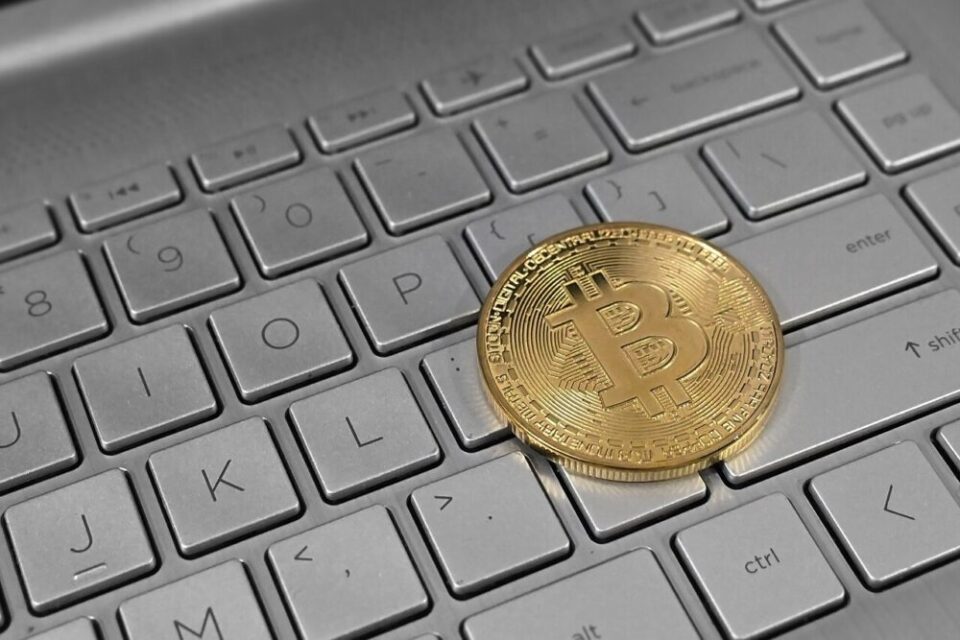 Монета биткойн върху клавиатура на лаптоп